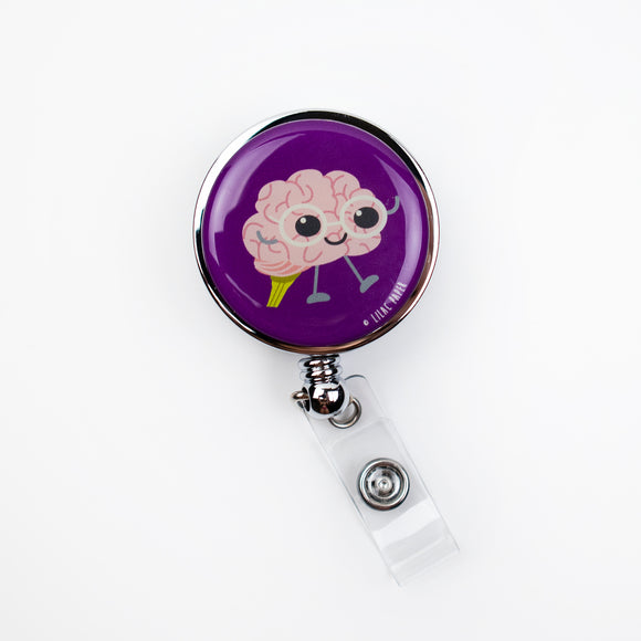 Lilac and Friends dental badge reel with cute-faced brain wearing glasses on purple background. Brainy dental badge reel for dental professionals by Lilac Paper.