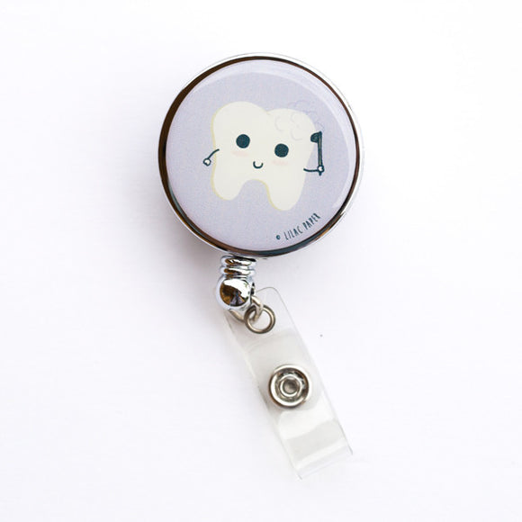 Lilac and Friends badge reel with white molar brushing itself on lavender background. Fluoride Bath dental badge reel for dental professionals by Lilac Paper.