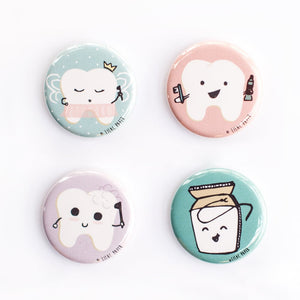 Set of four button magnets or pins featuring cute dental tooth characters in pastel colors.