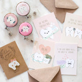 A pink and brown craft paper color scheme of pink badge reels, enamel pin, and greeting cards. Designed by Lilac Paper for Dental professionals and dental students.